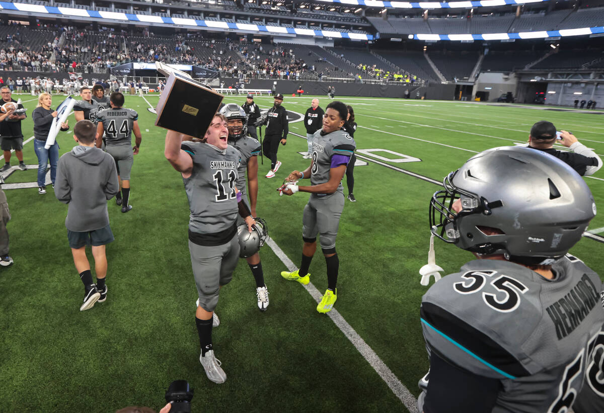 Silverado's Brandon Tunnell (11) raises the trophy while celebrating with teammates after defea ...