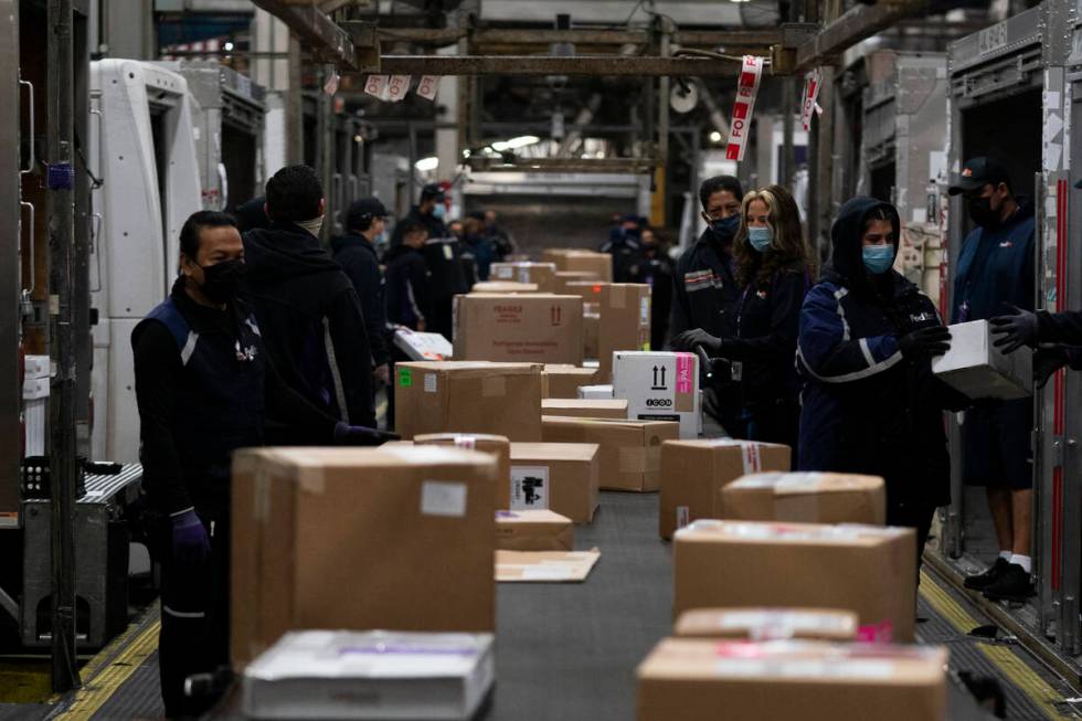 Employees sort packages for delivery at the FedEx regional hub at the Los Angeles International ...