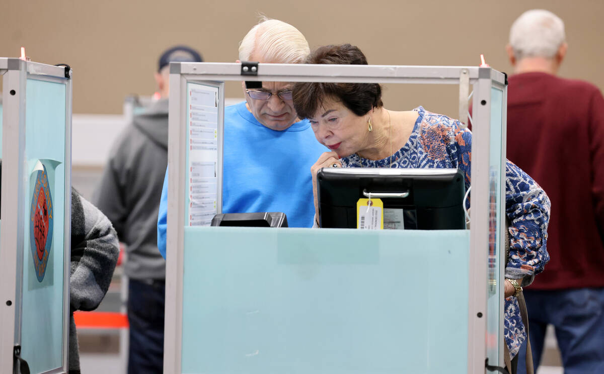 Voter Doris Burnett of Las Vegas casts her ballot with the help of her life partner Marshall Bi ...