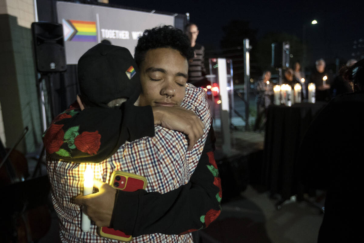 After reading a poem on stage, Jaden McKee, right, hugs his friend Justin Tyme during a vigil a ...