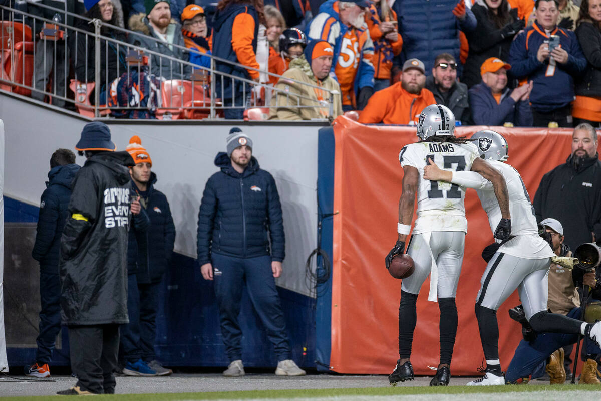 Raiders wide receiver Davante Adams (17) and quarterback Derek Carr (4) run into the tunnel aft ...