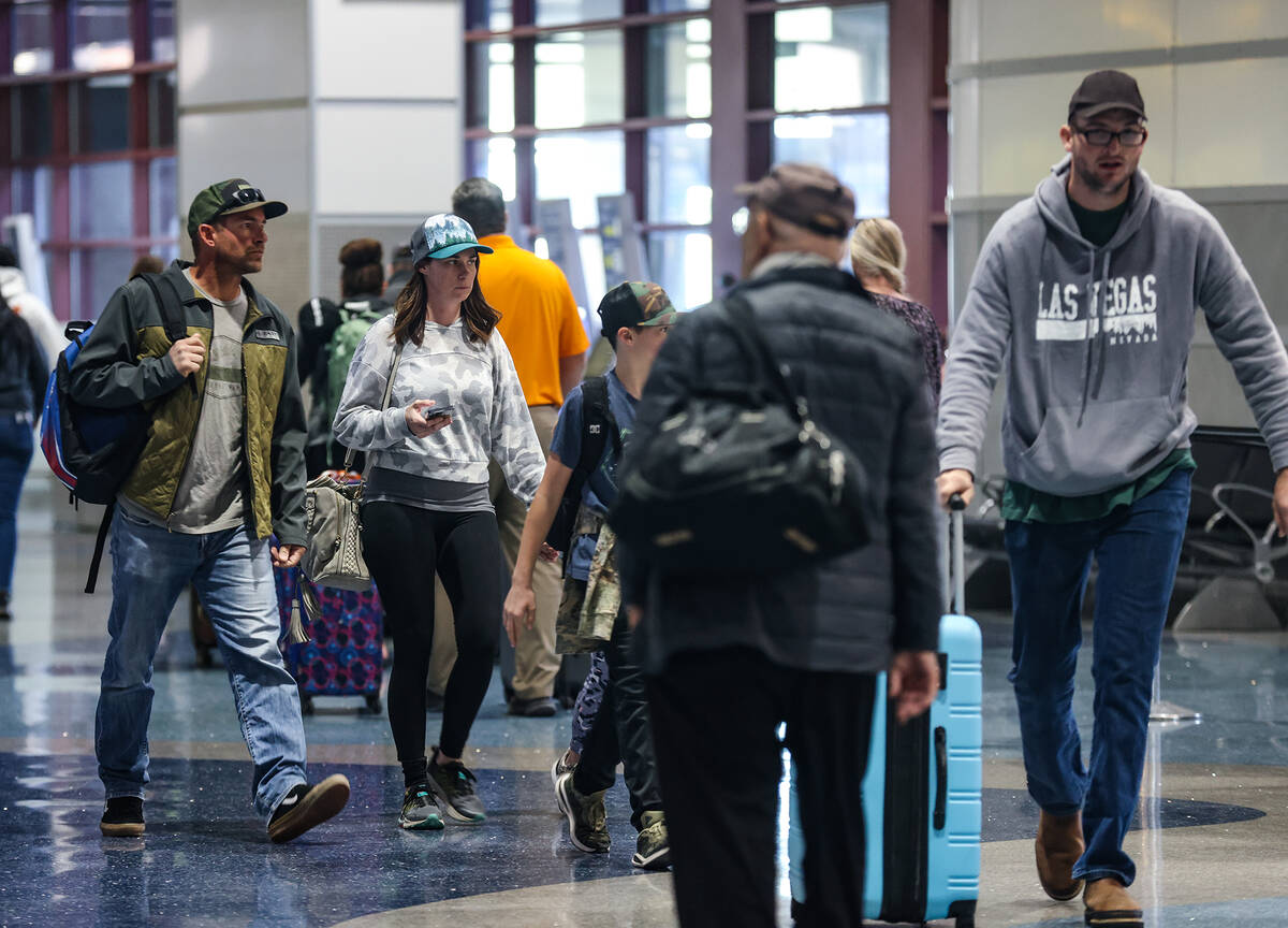 Travelers walk through Harry Reid International Airport in Las Vegas, Wednesday, Nov. 23, 2022. ...