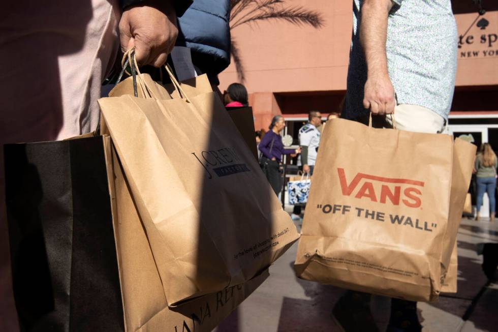 Shoppers carry their purchases during Black Friday sales at Las Vegas North Premium Outlets on ...