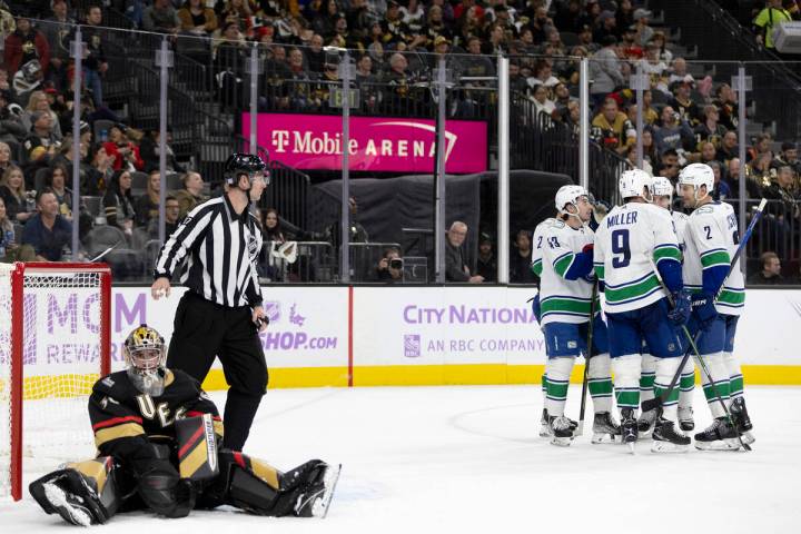 The Canucks celebrate their fifth goal of the night while Golden Knights goaltender Logan Thomp ...