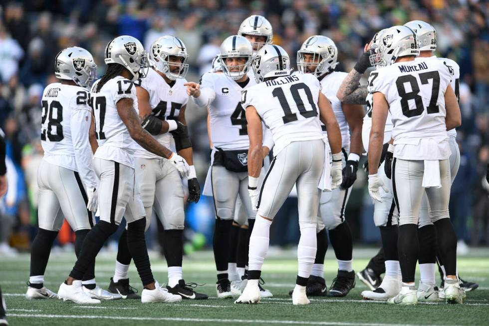 Las Vegas Raiders quarterback Derek Carr (4) directs teammates in the huddle during the first h ...