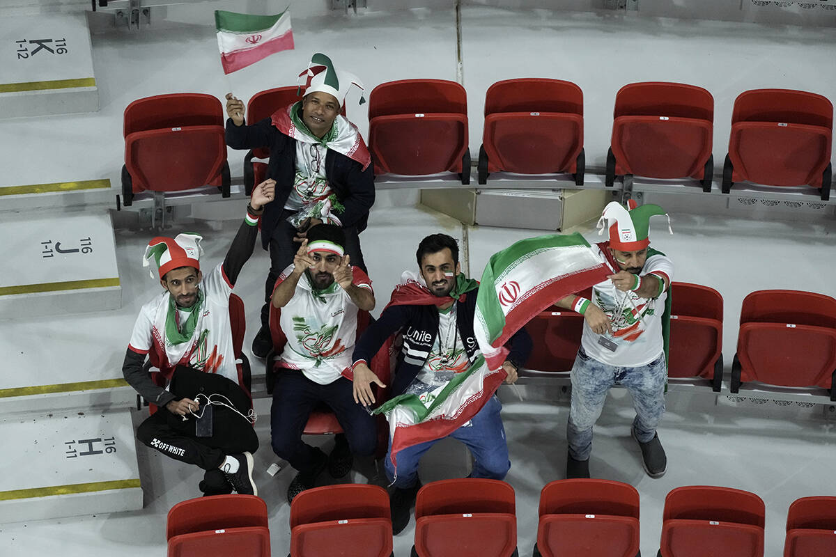 Iran supporters wave flags on the stands while waiting for the start of the World Cup group B s ...
