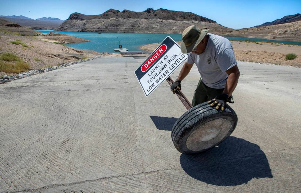 Rommel Garcia with the National Parks Service rolls away signage as the boat launch in Echo Bay ...