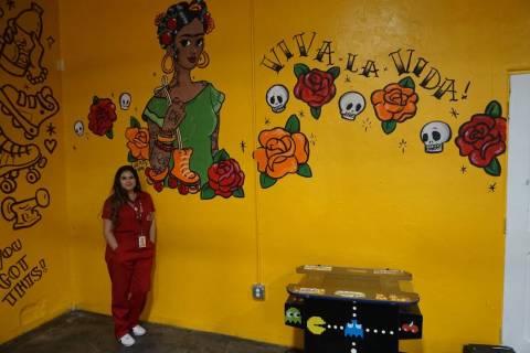 Amanda Quintanilla, owner of Fresa's Skate Shop poses next to a mural done by local artist Cher ...