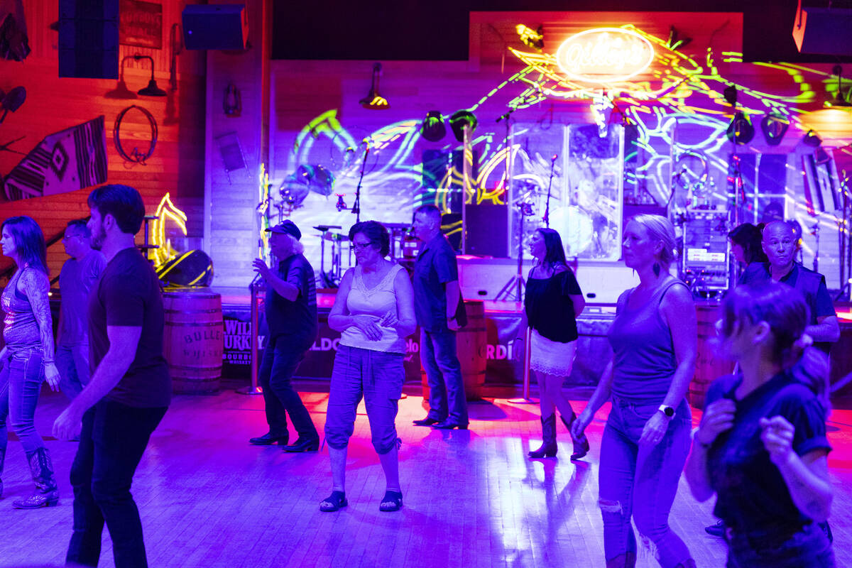 People dance at Gilley's Saloon inside of Treasure Island hotel-casino in Las Vegas, Friday, Au ...