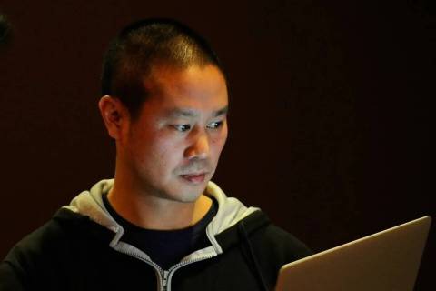 Zappos CEO Tony Hsieh works on his laptop before the start of the LaunchUp Las Vegas event at t ...