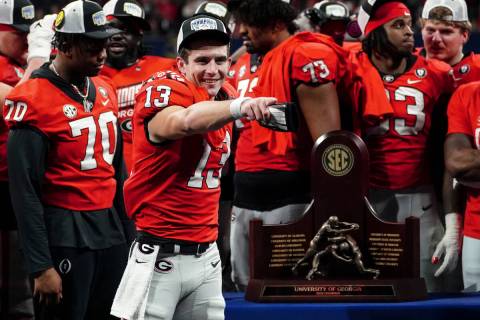 Georgia quarterback Stetson Bennett (13) gestures to the crowd during the trophy presentation t ...