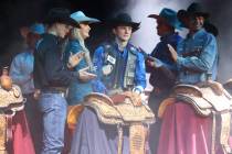Stetson Wright, center, is announced the champion of the bull riding competition during the 64t ...
