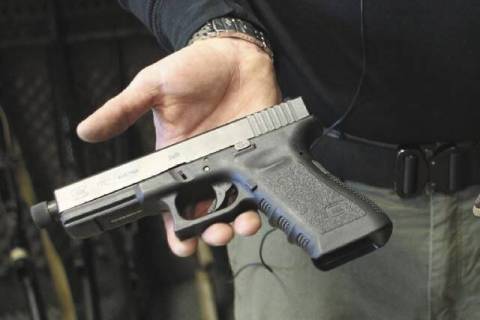Matt Supnick holds a Glock semi-automatic pistol in Las Vegas on Wednesday, Jan. 16, 2013. (Jer ...