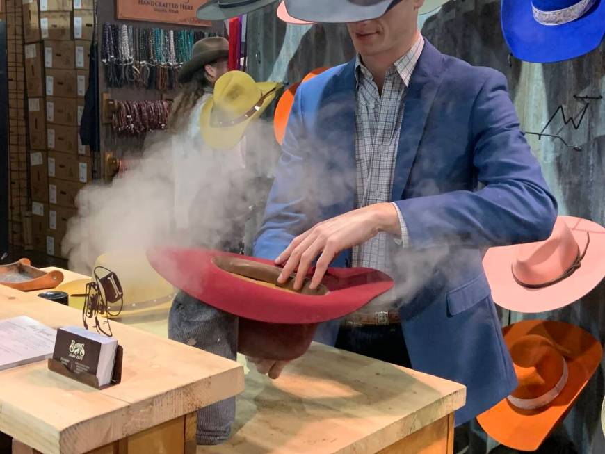 An expert hat shaper steams a cowboy hat for a customer at The Cowboy Channel Cowboy Christmas ...