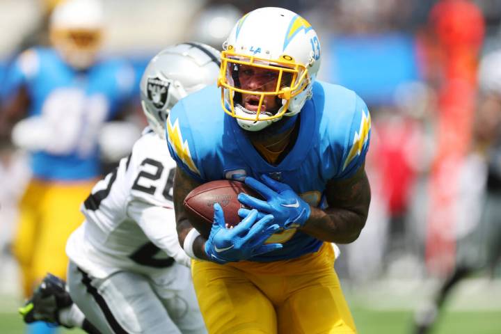 Los Angeles Chargers wide receiver Keenan Allen (13) makes a catch under pressure from Raiders ...