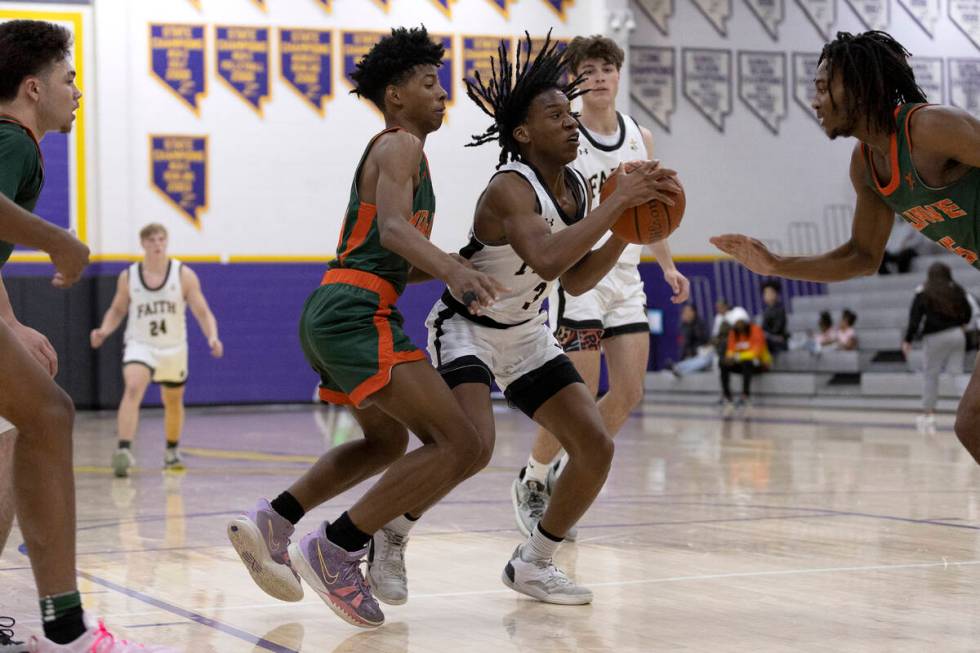 Faith Lutheran’s JohnPaul Agu (3) shoots between Mojave’s Zaccarion Jackson, cent ...