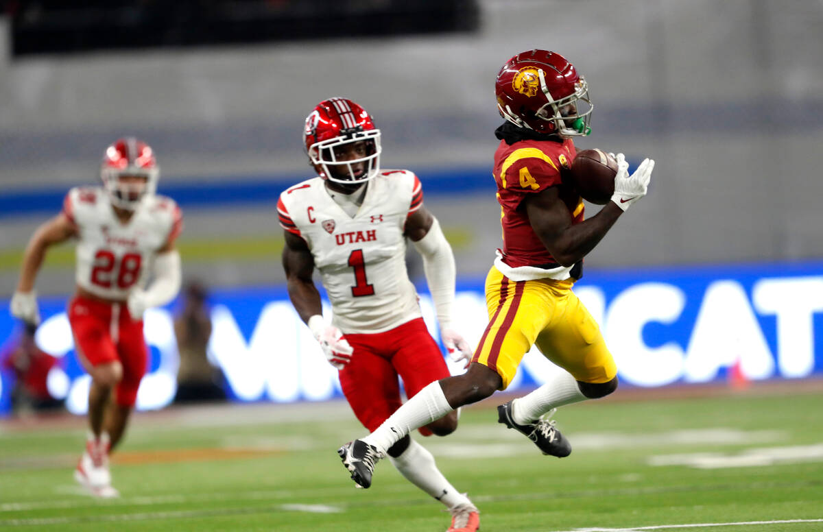 Southern California wide receiver Mario Williams (4) makes a pass reception ahead of Utah corne ...