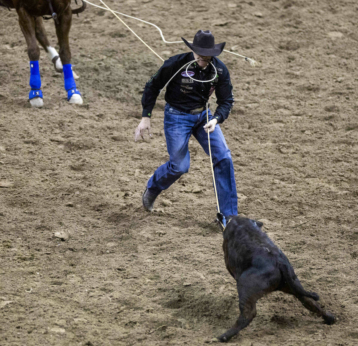 Marty Yates on Stephenville, TX., works the rope to his calf on his winning ride during Tie-Dow ...