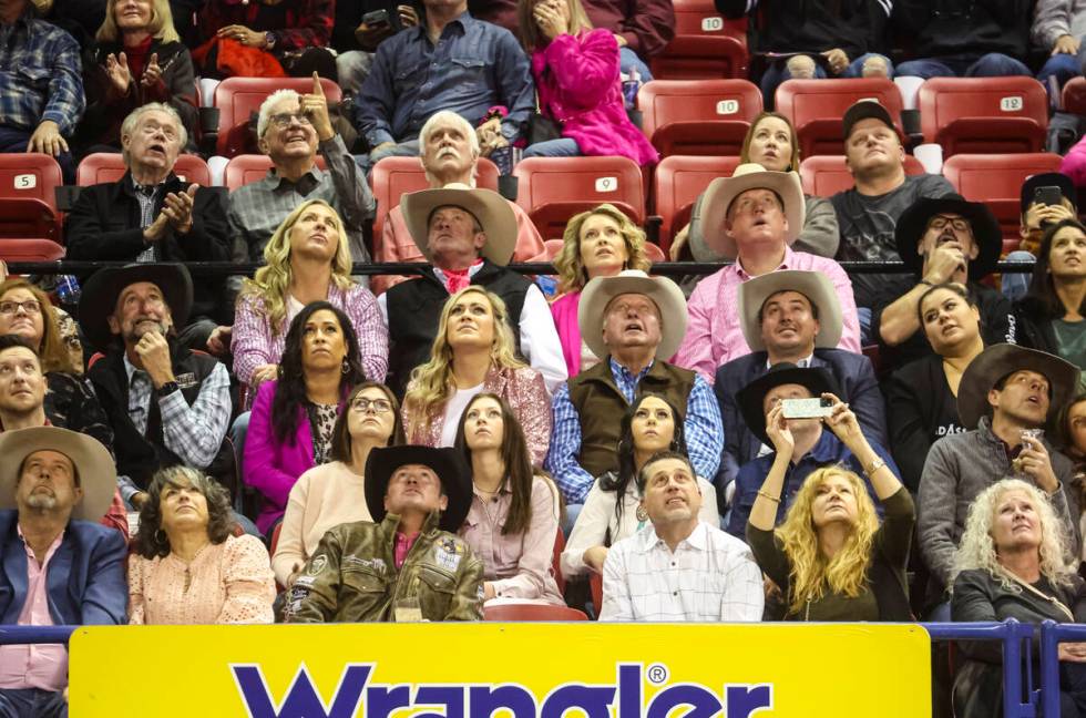 Attendees watch a replay during the fifth go-round of the National Finals Rodeo at the Thomas & ...