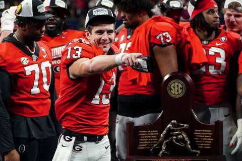 Georgia quarterback Stetson Bennett (13) gestures to the crowd during the trophy presentation t ...