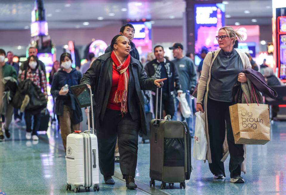 Travelers walk through the baggage claim at Harry Reid International Airport in Las Vegas, Wedn ...