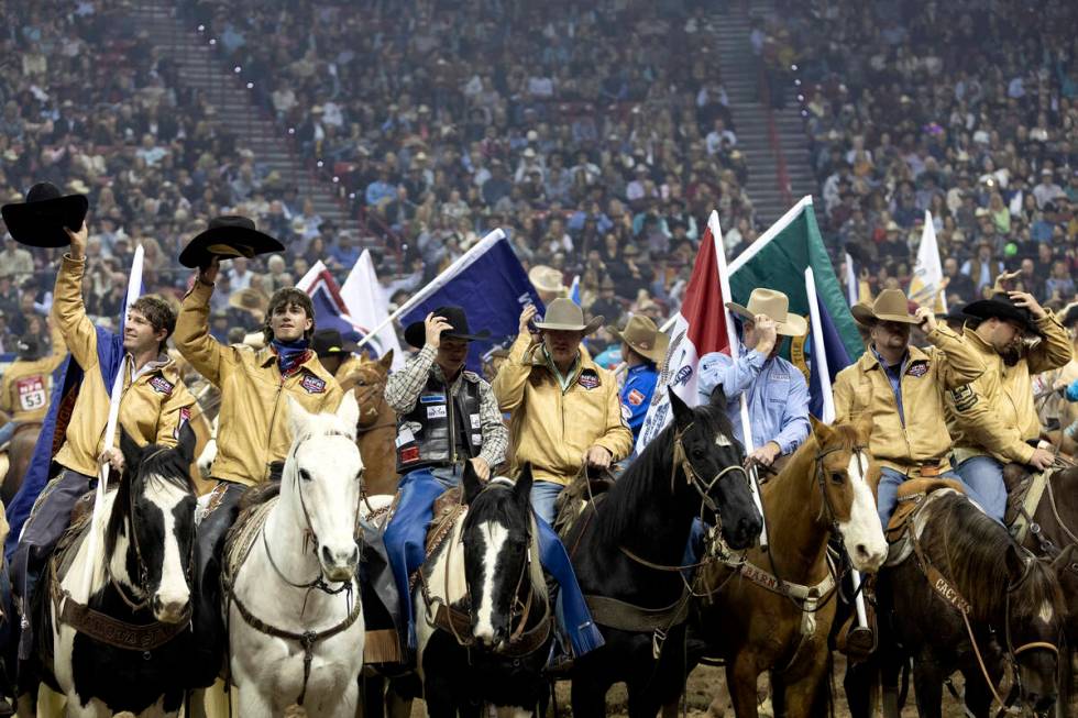 Cowboys salute the crowd with their hats before competing during the sixth go-round of the Nati ...