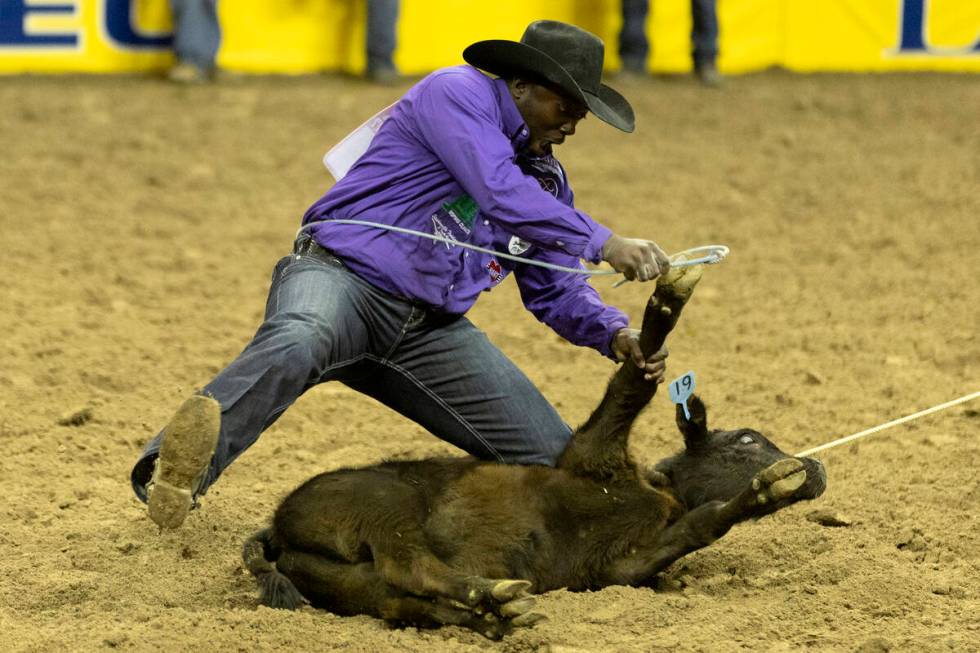 John Douch, of Huntsville, Tex., competes in tie-down roping during the sixth go-round of the N ...