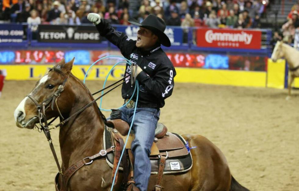 Logan Medlin of Tatum, N.M., celebrates after competing in the team roping event during the nin ...