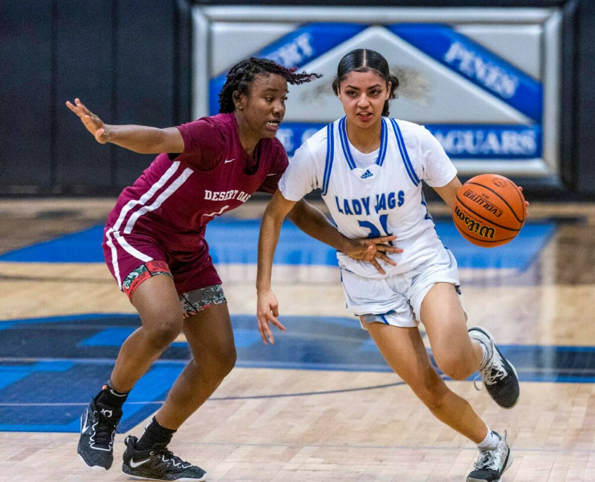 Desert Oasis guard La'Niah Hicks (1) keeps a tight defense on Desert Pines guard Destiny Sao Ma ...