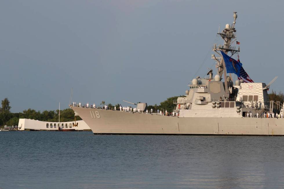 Sailors aboard the the USS Daniel Inouye render honors while passing the USS Arizona Memorial a ...