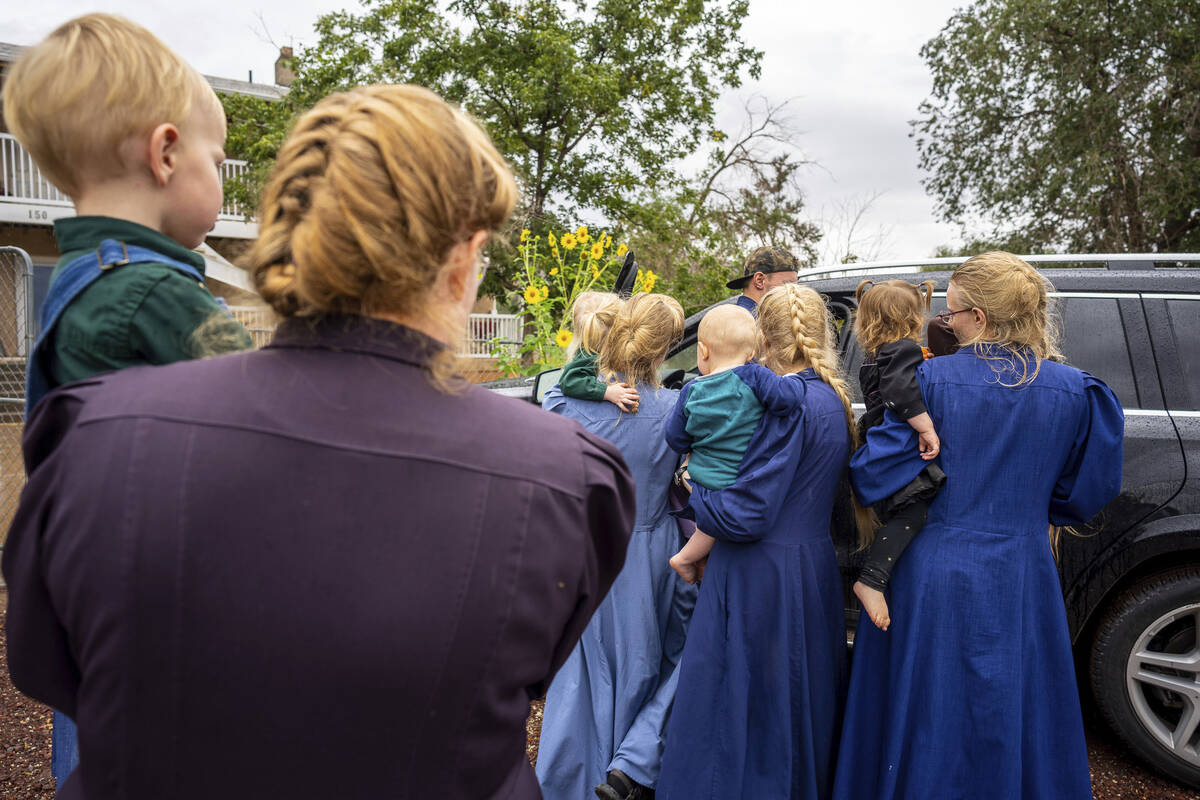 Family and followers of Samuel Bateman gather around as he calls from police custody following ...