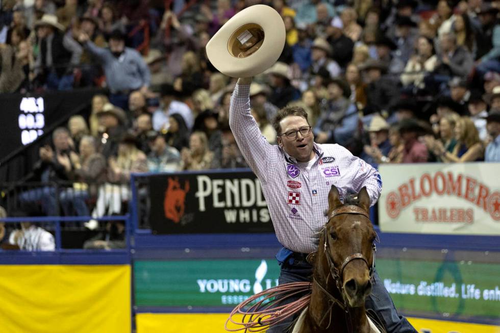 Coleman Proctor, of Pryor, Okla., takes a victory lap after winning in team roping during the e ...