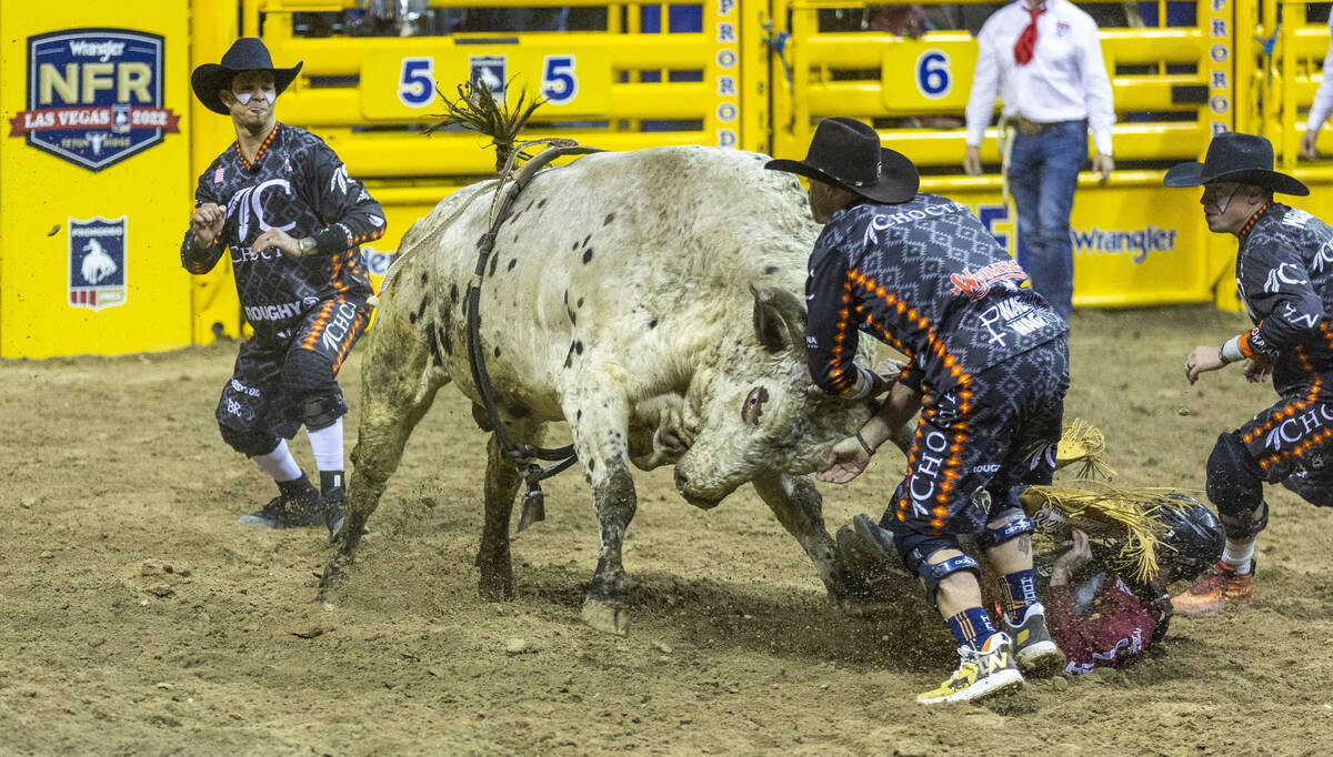 Bullfighter engage a bull to protect rider Trevor Kastner of Roff, Okla., down on the dirt in B ...
