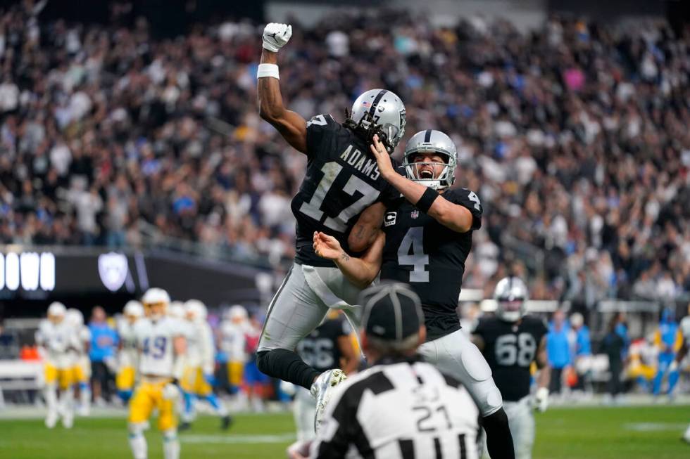 Las Vegas Raiders quarterback Derek Carr (4) and wide receiver Davante Adams (17) celebrate the ...