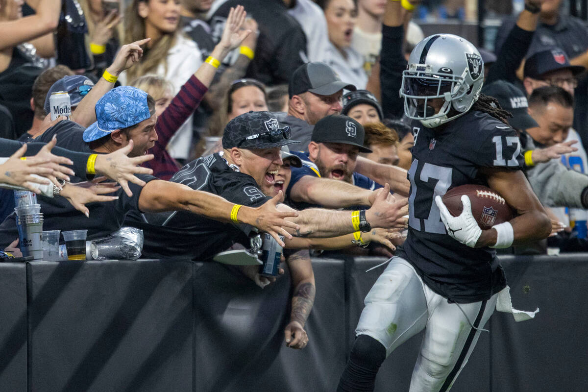 Raiders wide receiver Davante Adams (17) is congratulated by fans after scoring a touchdown dur ...