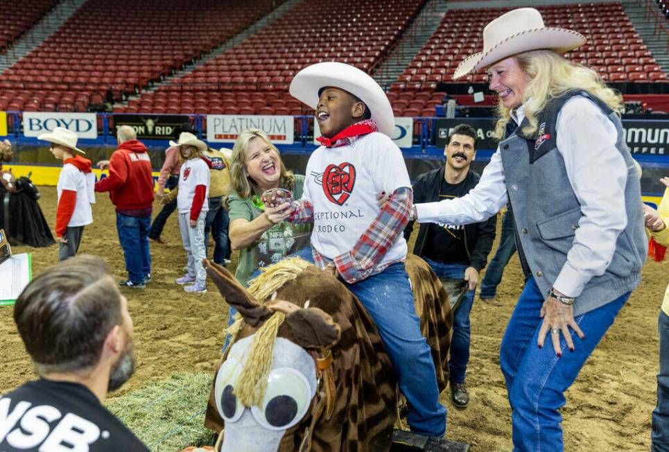 Participant Jeremiah Brown, 8, is assisted by Glee Nett, right, and Ruthie Campbell, left, as h ...