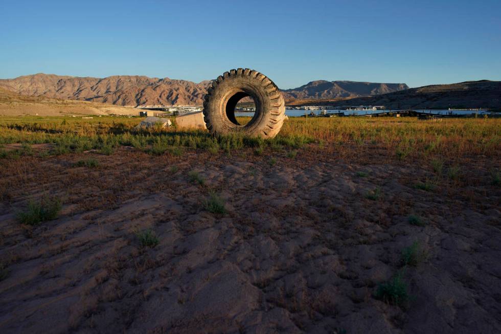 A truck tire once in the water as part of a marina sits on dry ground as water levels have drop ...