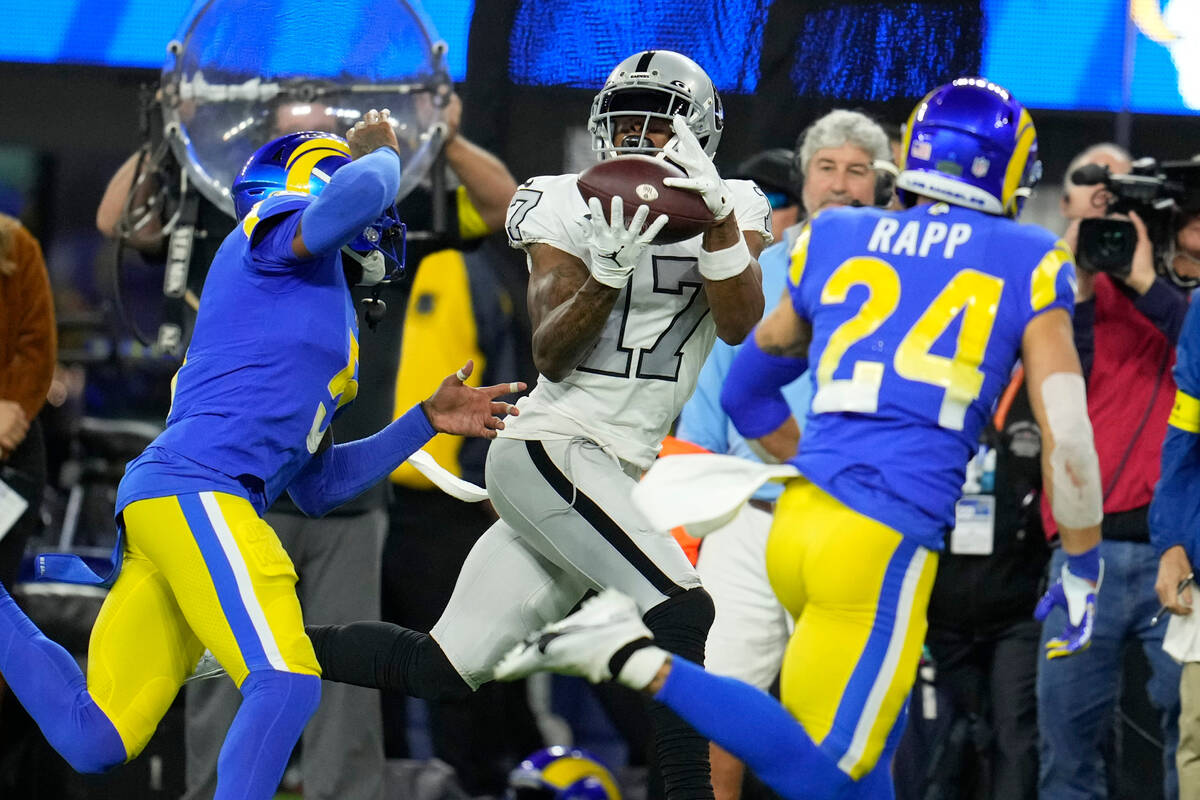 Las Vegas Raiders wide receiver Davante Adams, center, makes a catch as Los Angeles Rams corner ...