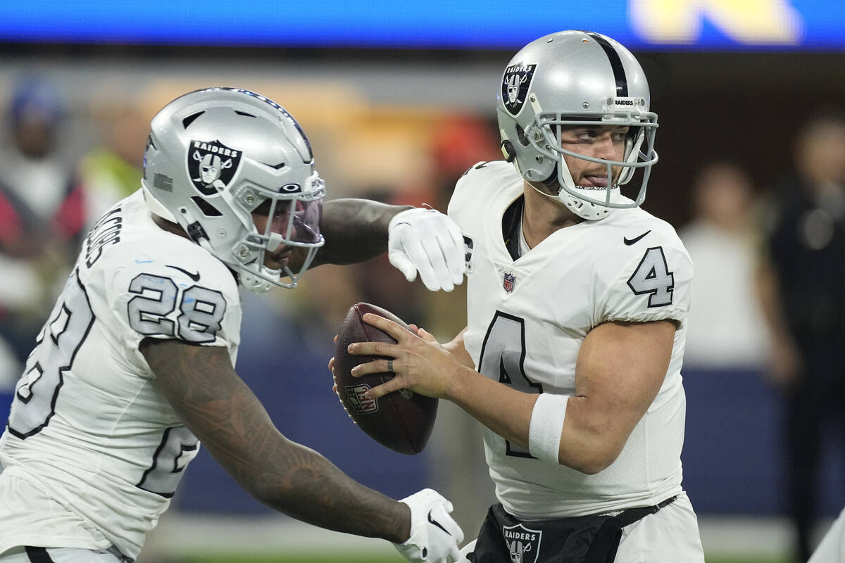 Las Vegas Raiders quarterback Derek Carr drops back as running back Josh Jacobs gets ready for ...