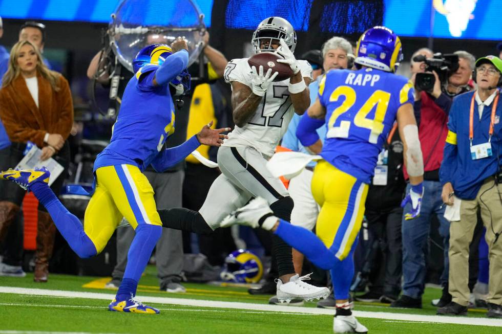 Las Vegas Raiders wide receiver Davante Adams, center, makes a catch as Los Angeles Rams corner ...