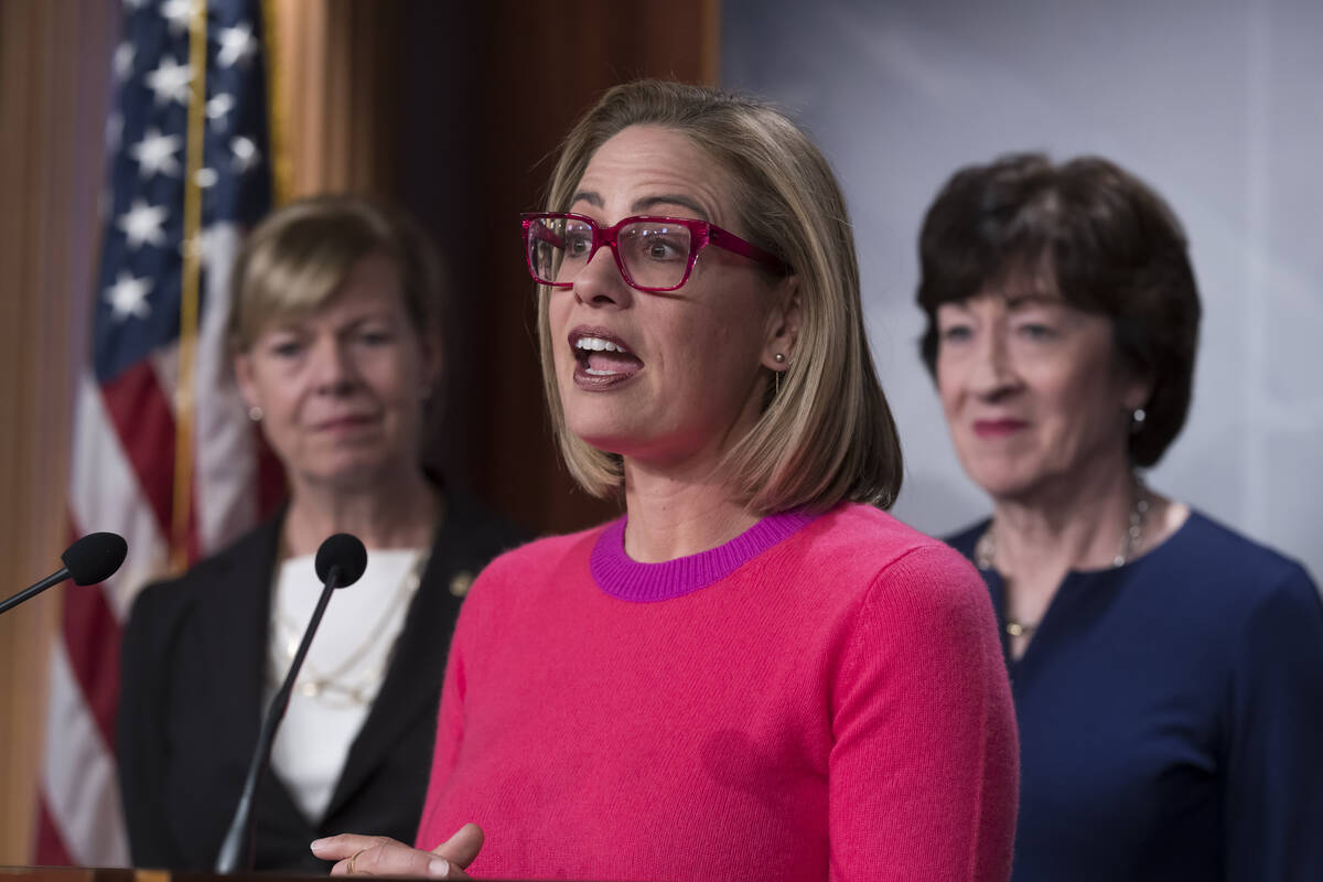 FILE - Sen. Kyrsten Sinema, D-Ariz., flanked by Sen. Tammy Baldwin, D-Wis., left, and Sen. Susa ...