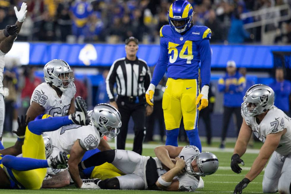 Raiders quarterback Derek Carr (4) picks up a fourth down conversion as Los Angeles Rams lineba ...