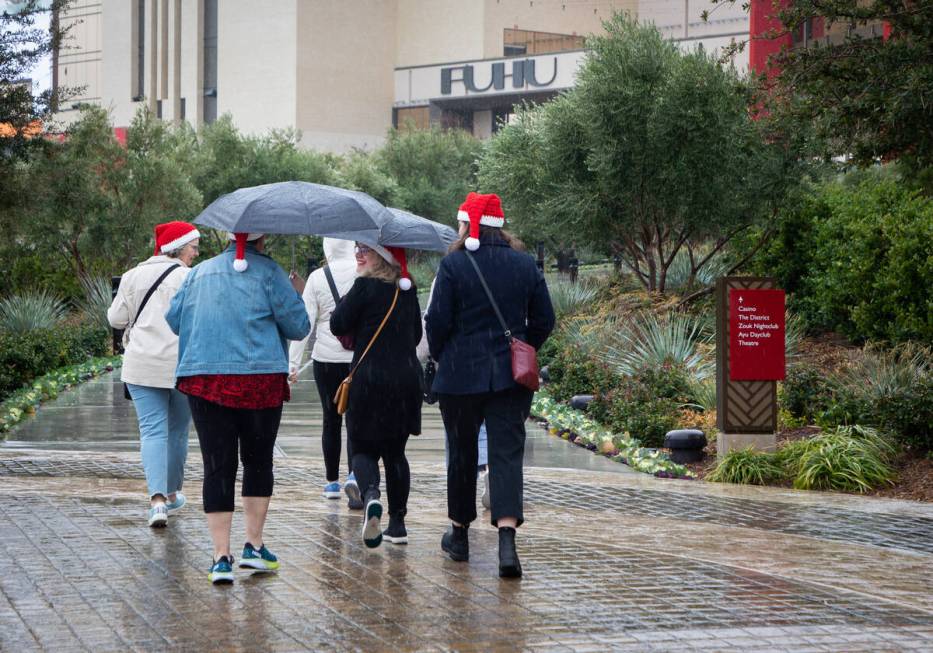 People walk in the rain on the Strip on Sunday, Dec. 11, 2022 in Las Vegas. (Amaya Edwards/Las ...