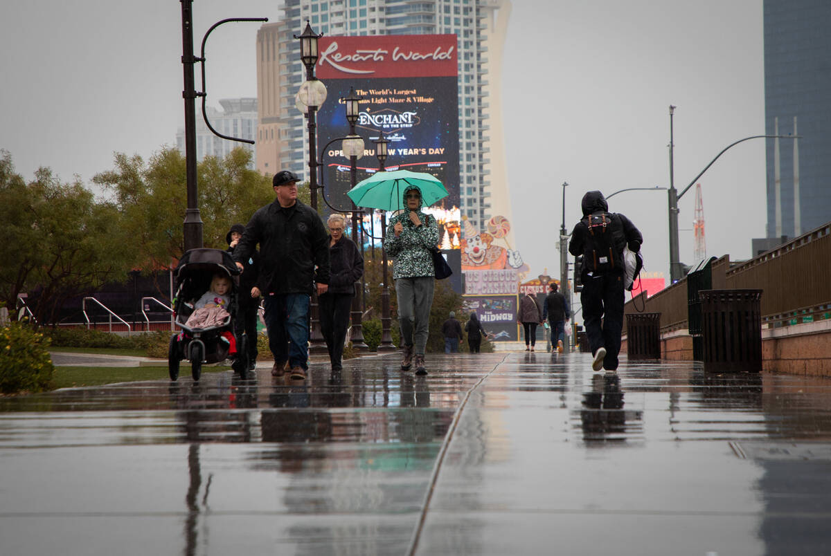 People walk in the rain on the Strip on Sunday, Dec. 11, 2022 in Las Vegas. (Amaya Edwards/Las ...