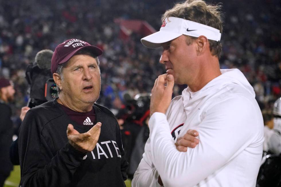 Mississippi State coach Mike Leach, left, talks with Mississippi coach Lane Kiffin before an NC ...