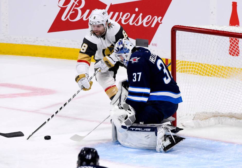 Vegas Golden Knights' Phil Kessel (8) takes a shot on Winnipeg Jets goaltender Connor Hellebuyc ...