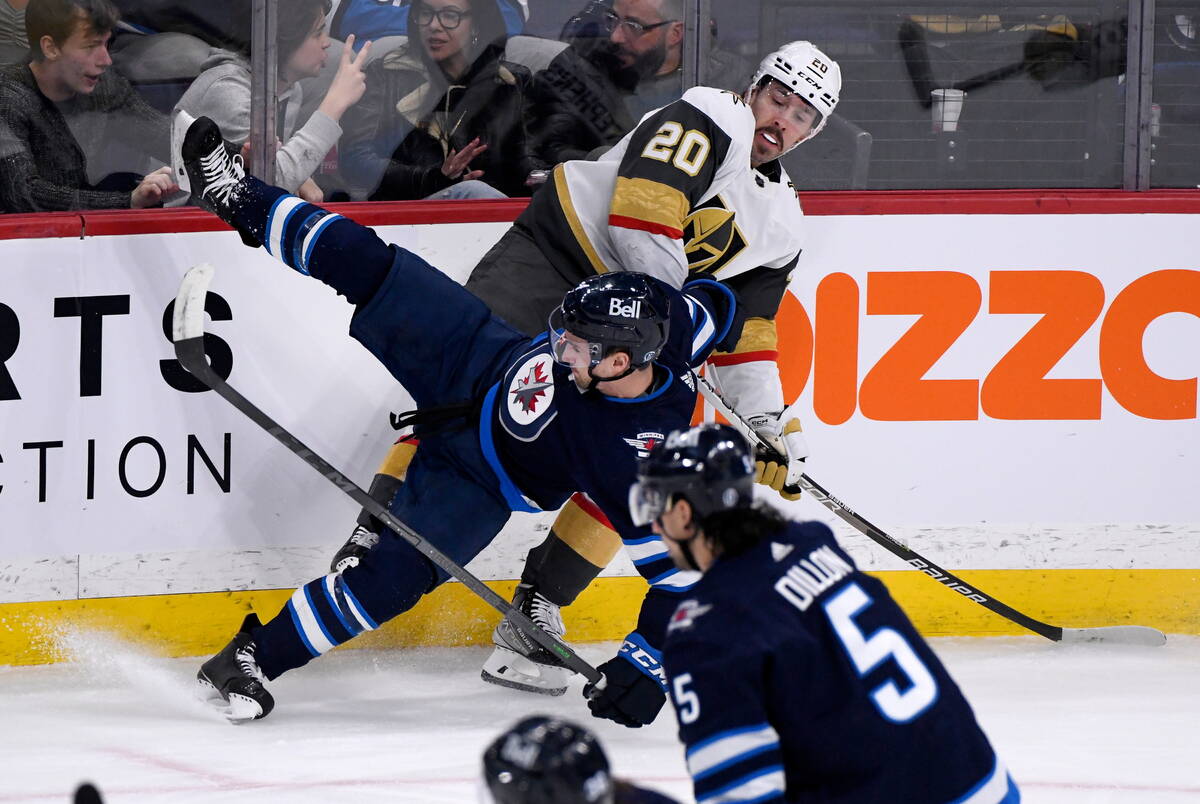 Vegas Golden Knights' Chandler Stephenson (20) checks Winnipeg Jets' Neal Poink (4) during the ...