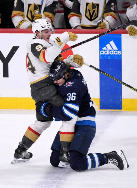 Winnipeg Jets' Morgan Barron (36) grabs hold of Vegas Golden Knights' Brayden Pachal (94) durin ...