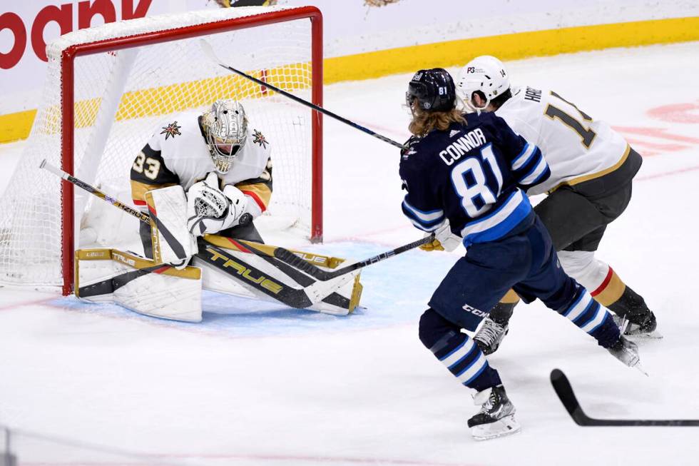 Vegas Golden Knights goaltender Adin Hill (33) makes a save on Winnipeg Jets' Kyle Connor (81) ...