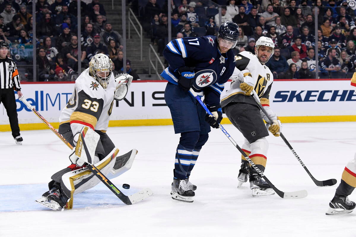 Vegas Golden Knights goaltender Adin Hill (33) makes a save as Winnipeg Jets' Adam Lowry (17) a ...